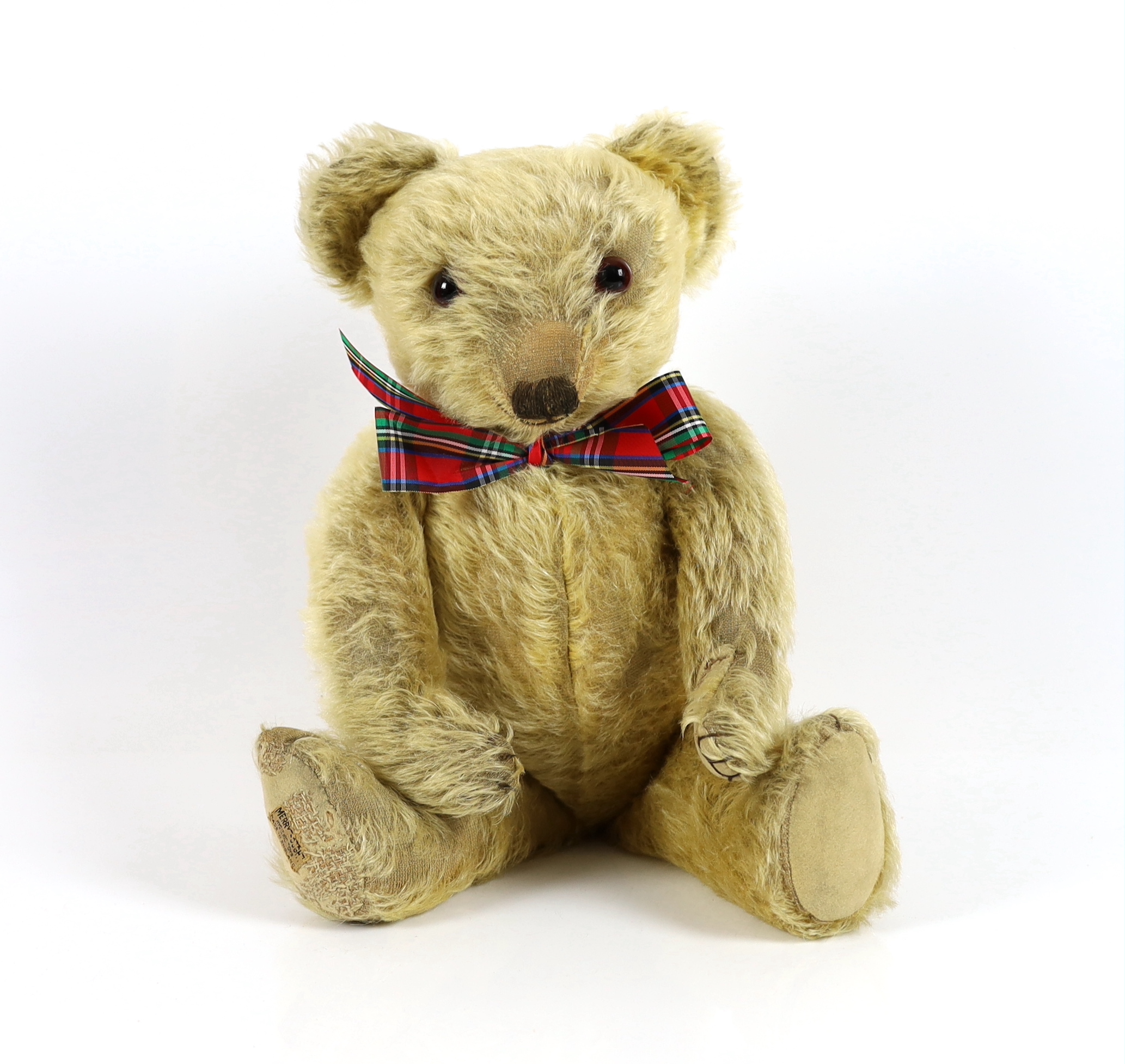 A 1930's Merrythought bear, with label, 44cm, old repair to foot, some hair loss